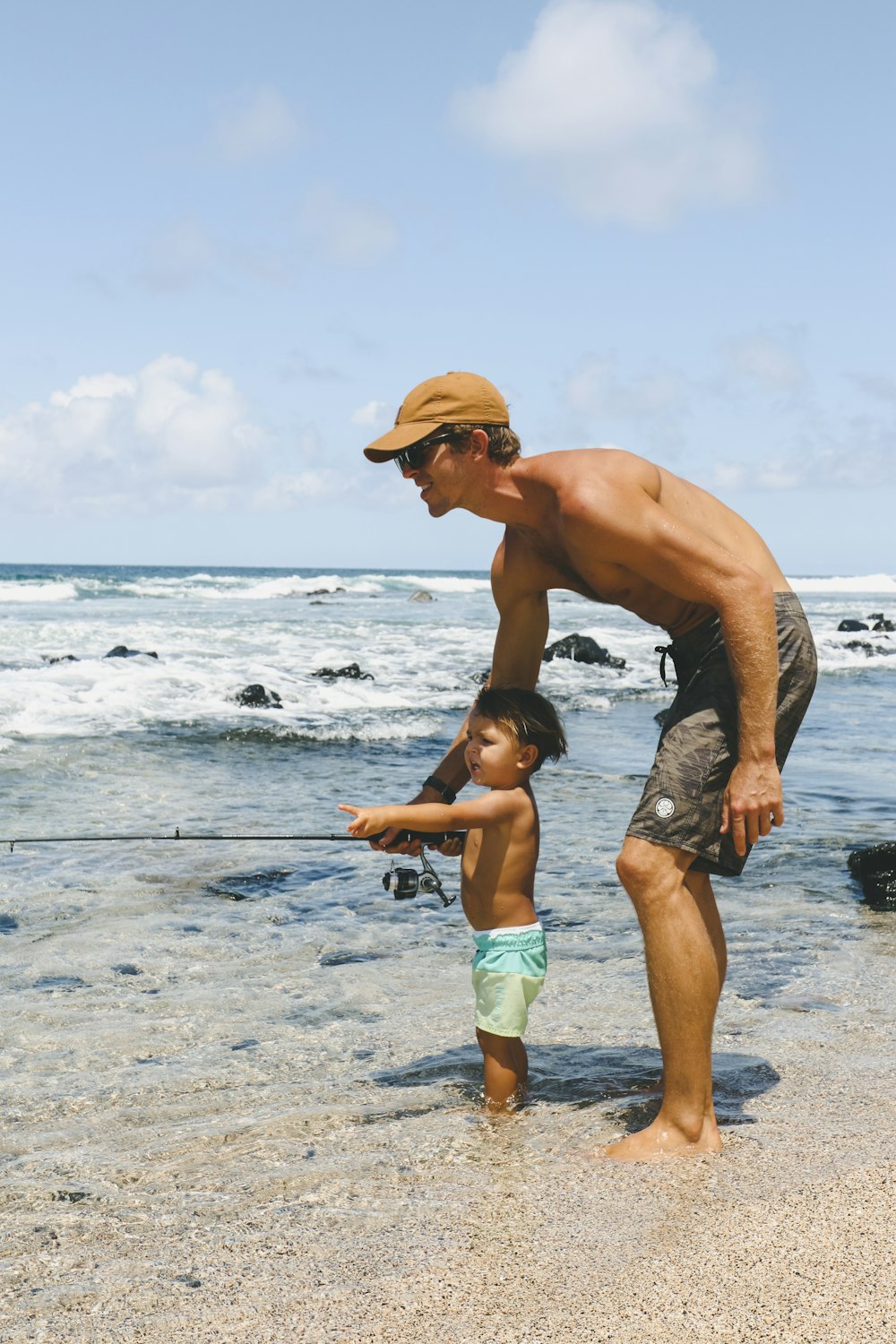 man in blue shorts and brown hat running on beach during daytime