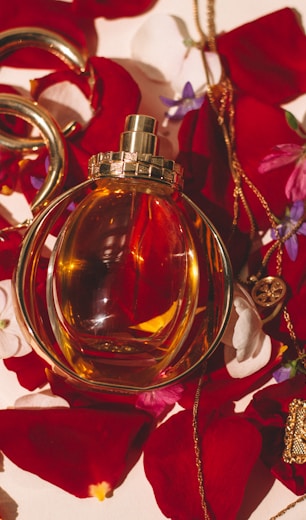 gold perfume bottle on red and white floral textile