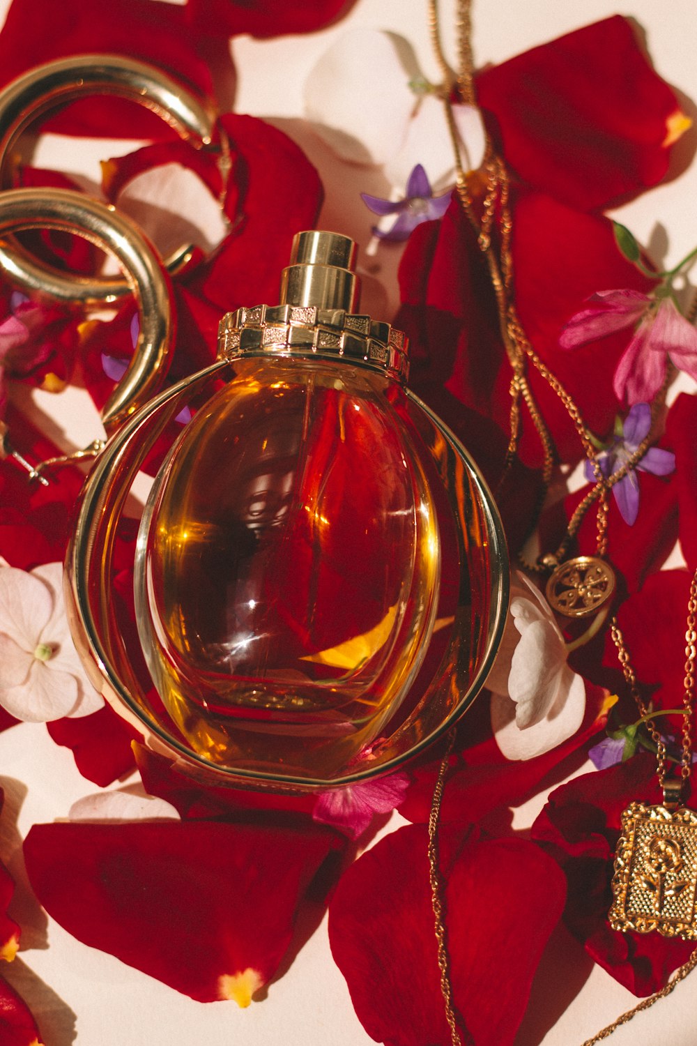 gold perfume bottle on red and white floral textile