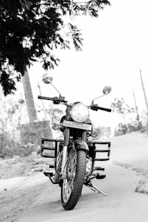 Close-up of a shiny classic motorbike parked beside a rustic village road.