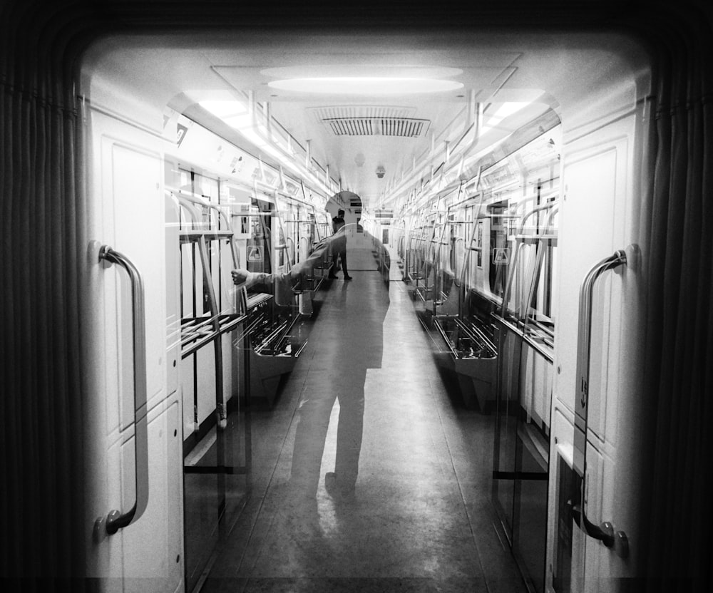 grayscale photo of people walking on train station