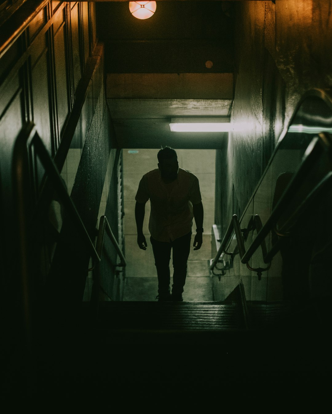 man in black t-shirt walking on the hallway