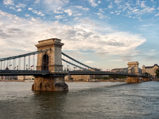 brown bridge under blue sky and white clouds during daytime in Széchenyi Chain Bridge Hungary