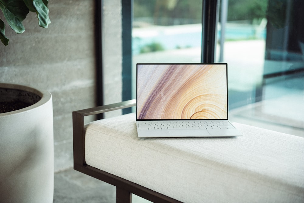 silberner Laptop auf braunem Holztisch