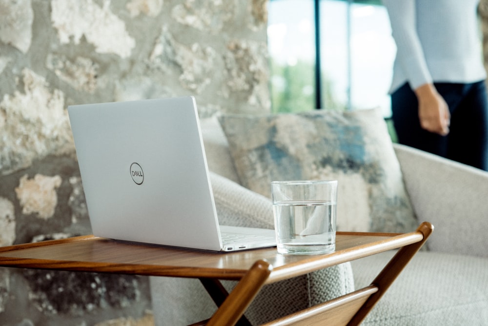 silver laptop on brown wooden table