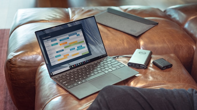 black and gray laptop computer on brown leather couch