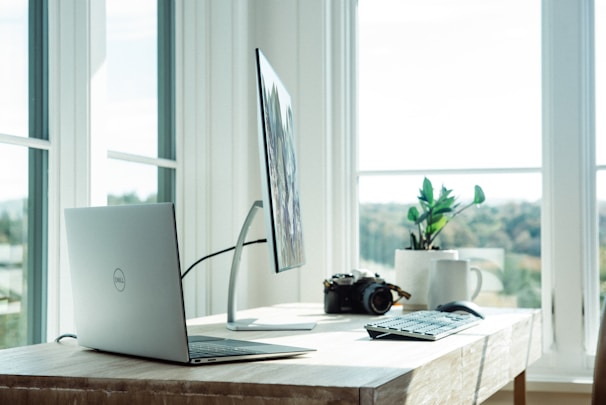 A serene workspace with a laptop open to a chat window, soft natural light filtering through a nearby window.