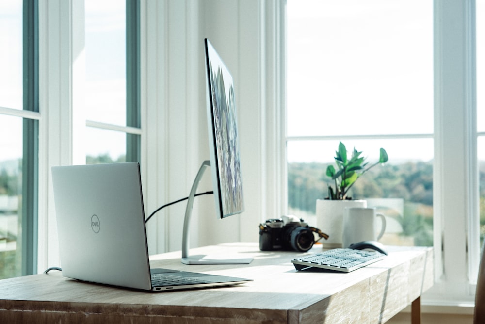 silver laptop on white table