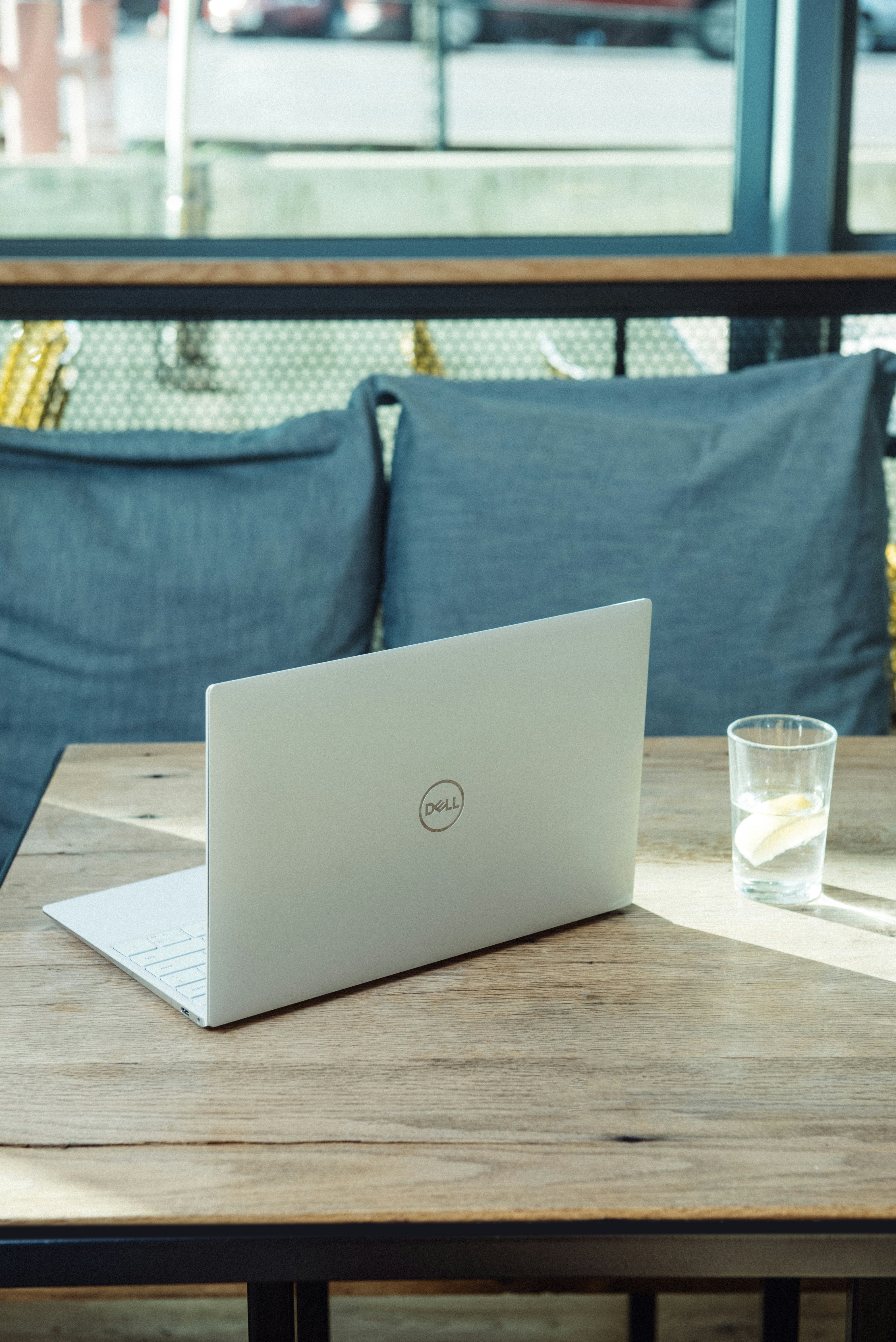 silver laptop on brown wooden table