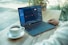 person using black laptop computer on brown wooden table