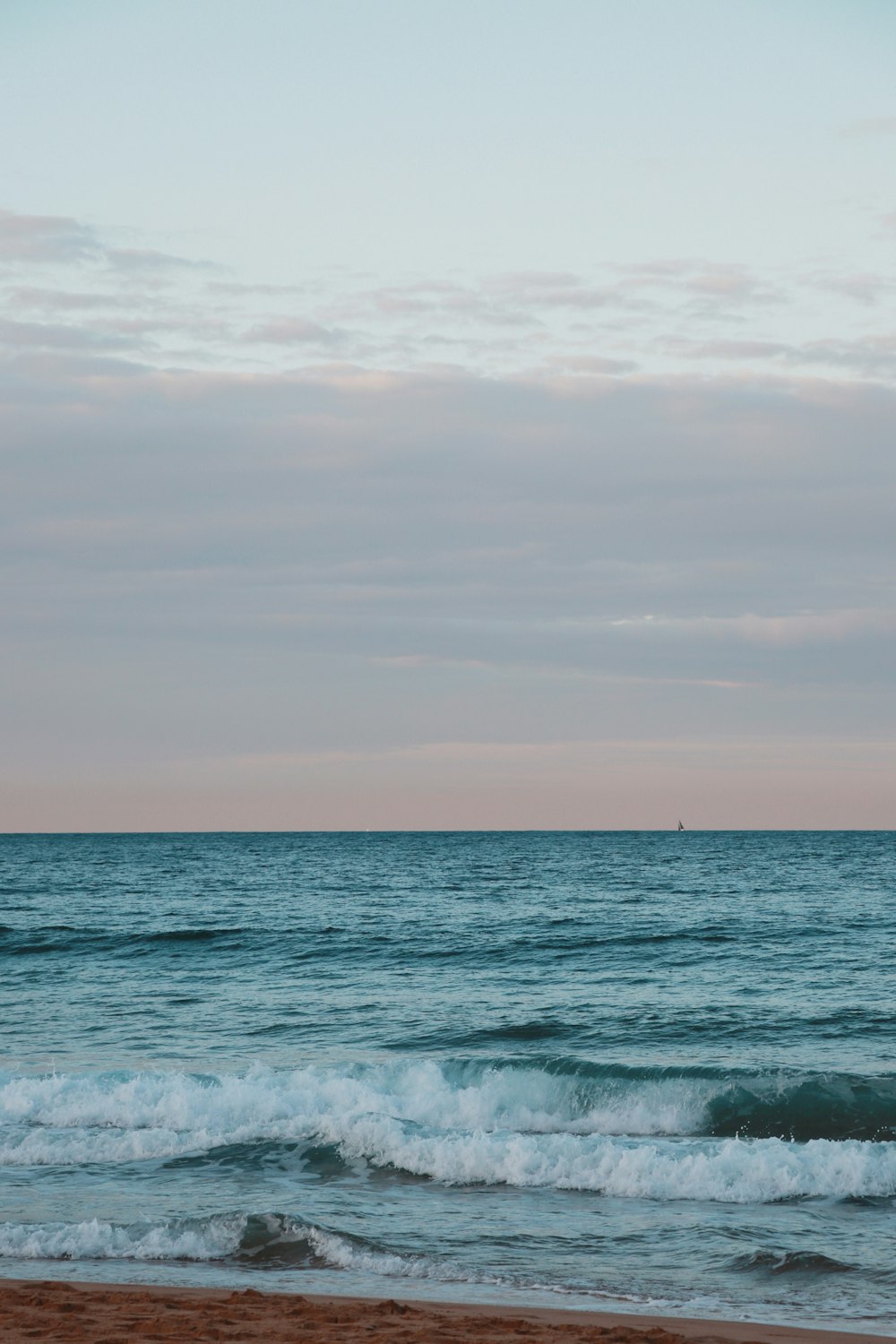 ocean waves under cloudy sky during daytime