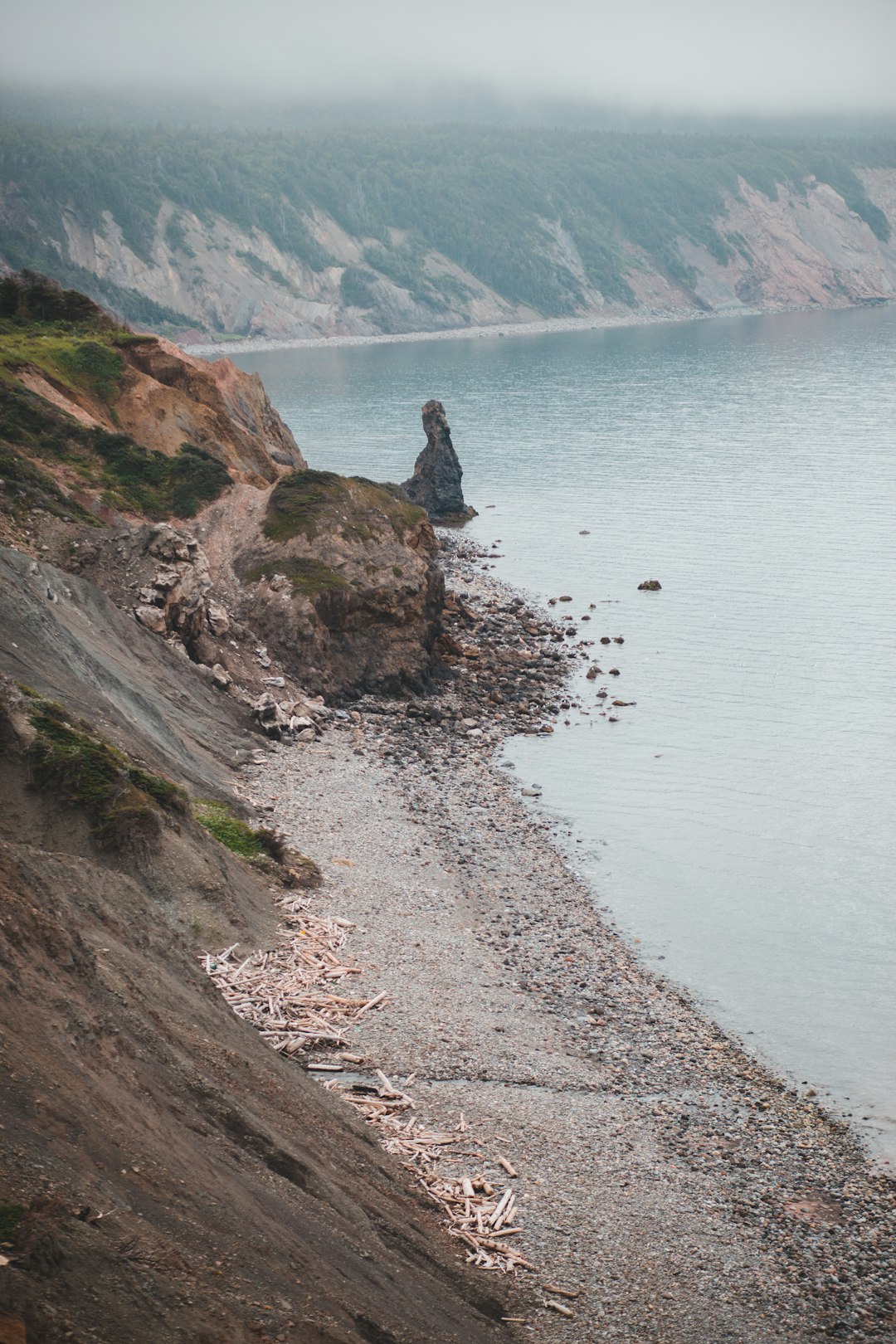 person sitting on rock near body of water during daytime