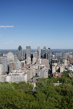 Drone view of a vibrant city skyline with skyscrapers under a clear blue sky.