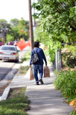 A customer unloading groceries from a car trunk, using sturdy himgreen bags on a bright morning.