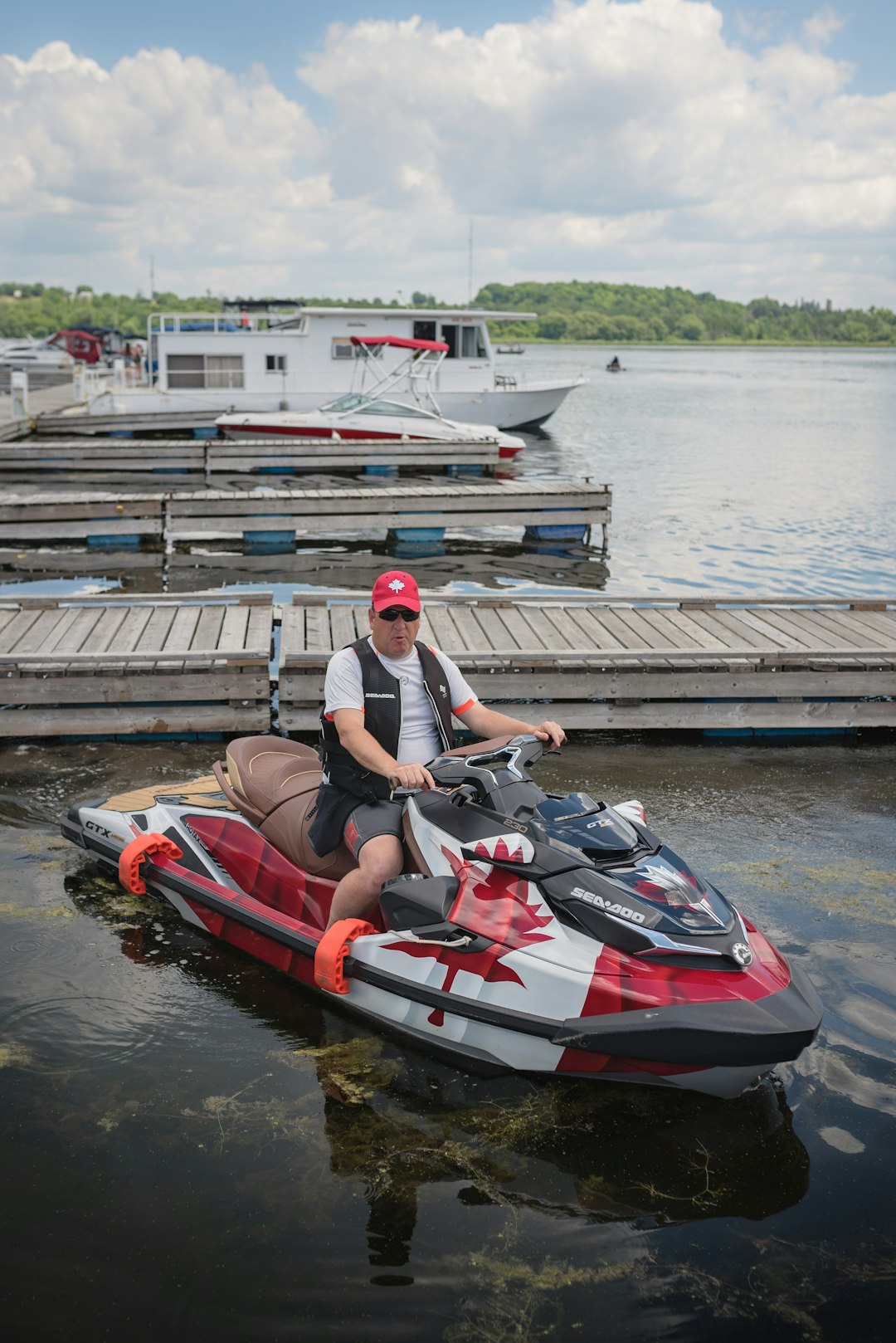 woman in white tank top riding red and white personal watercraft