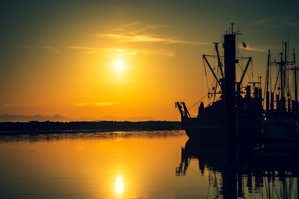 silhouette of boat on sea during sunset