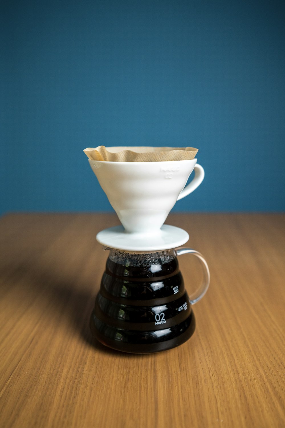 taza de té de cerámica blanca sobre mesa de madera marrón
