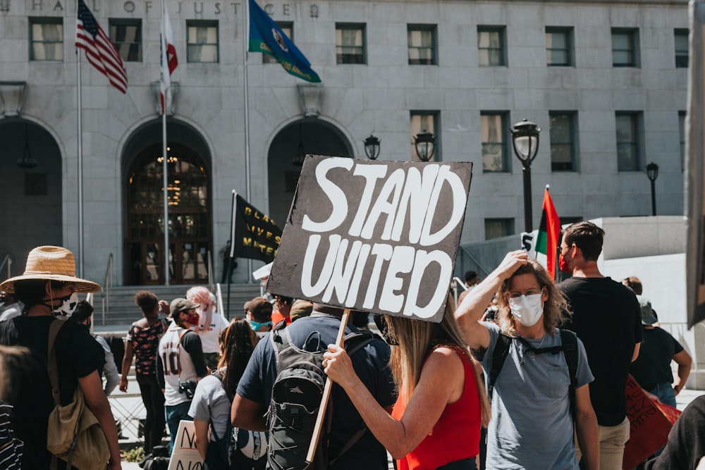 people in white and red shirts standing on street during daytime