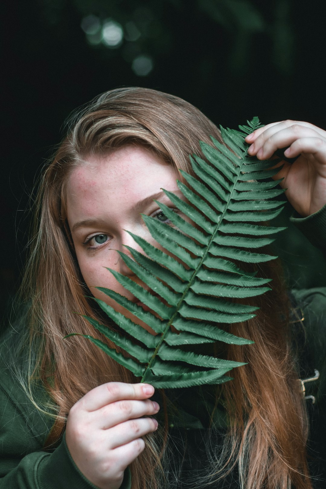 woman holding green leaf plant