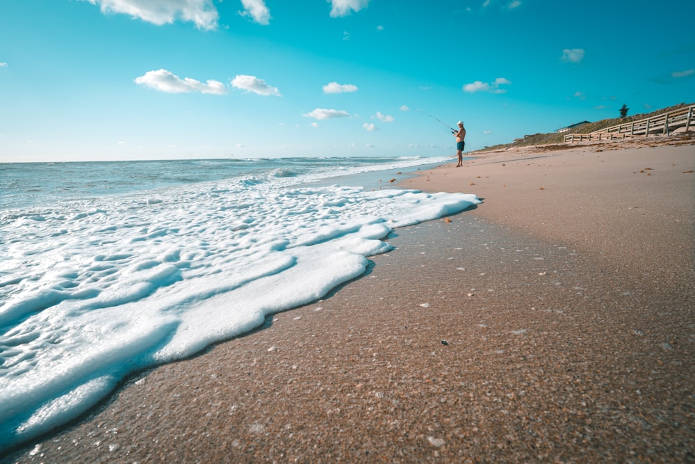 person standing on beach shore during daytime