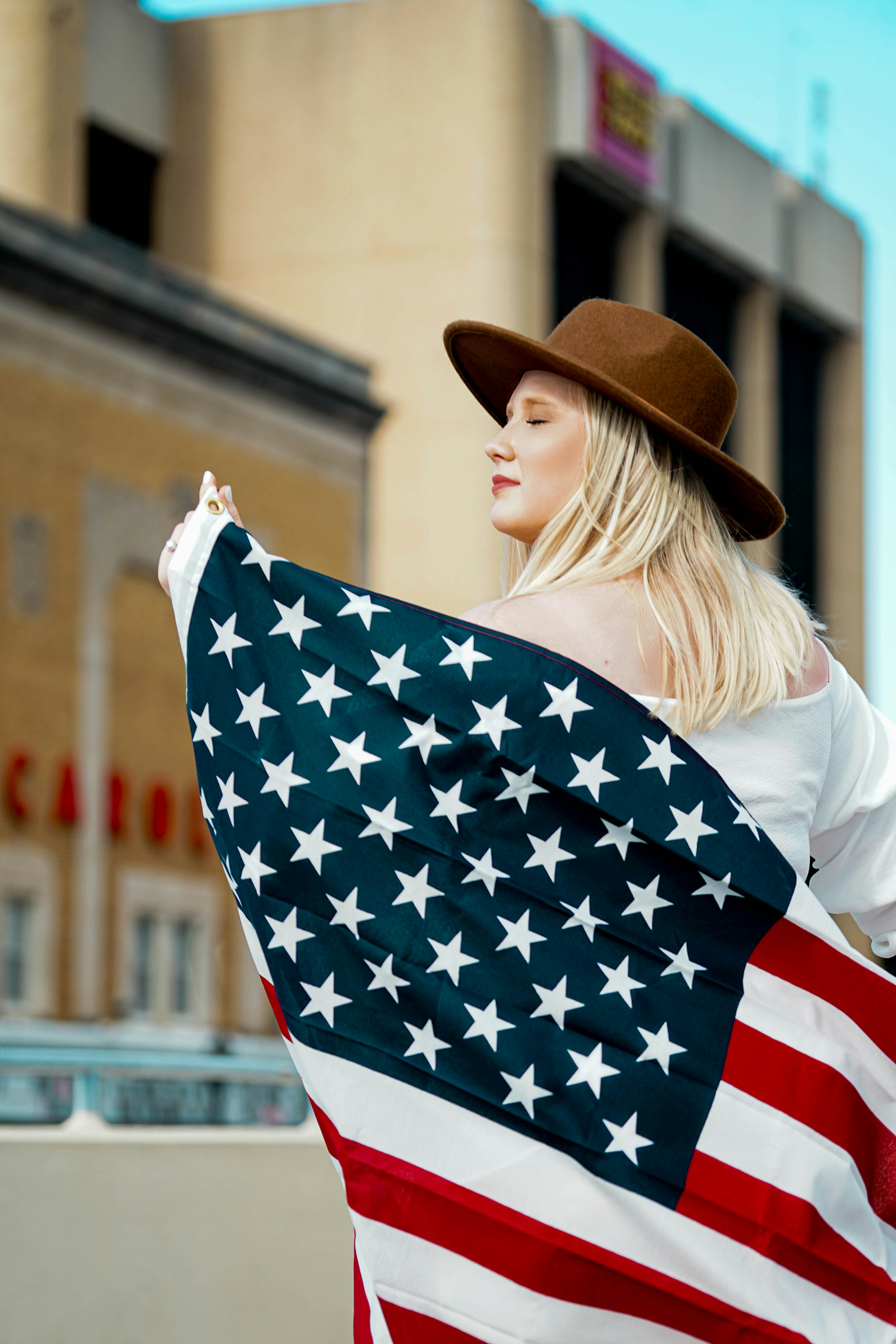 woman in white shirt holding blue and white star print textile during daytime