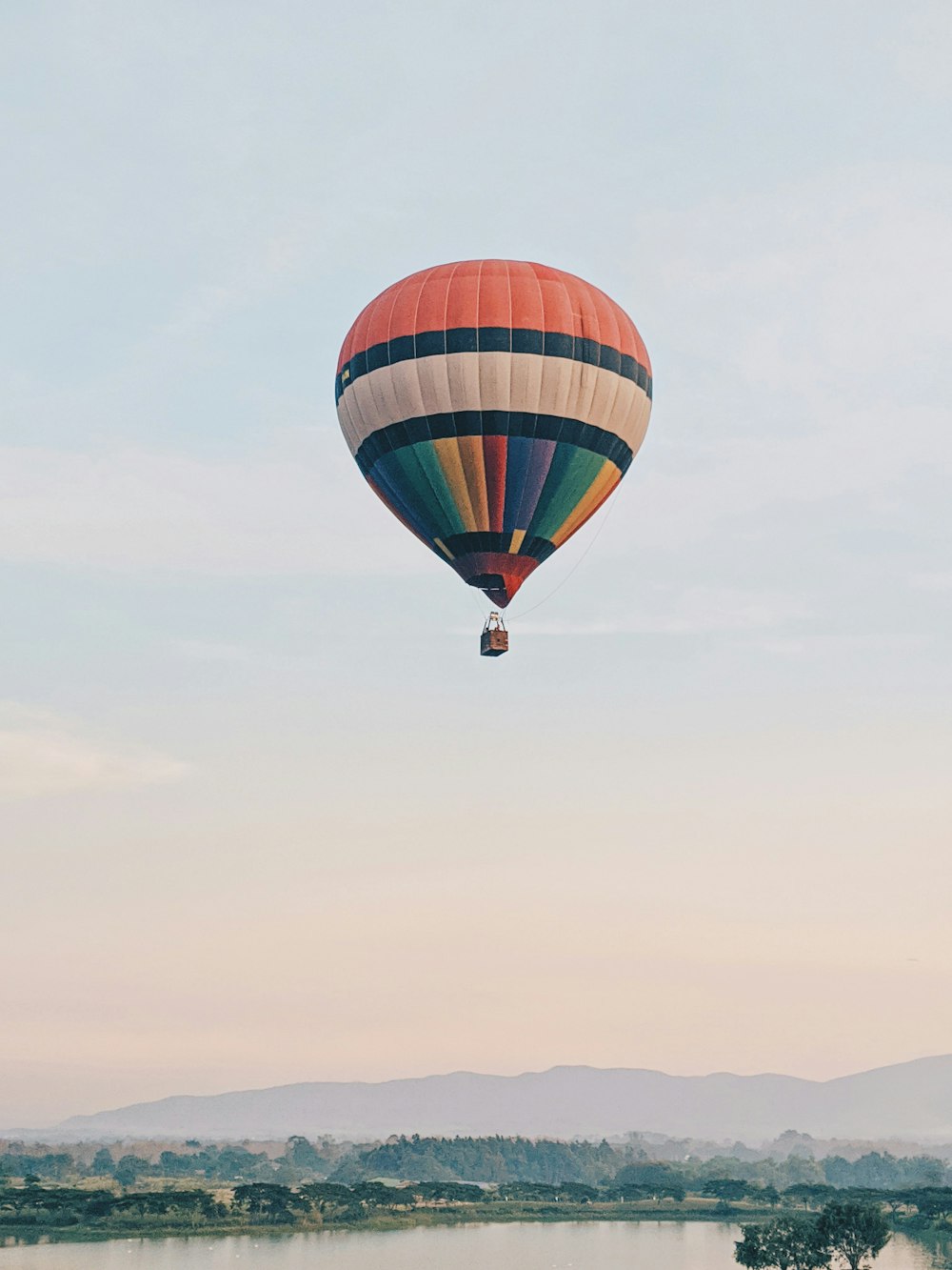 blue red and yellow hot air balloon in mid air during daytime