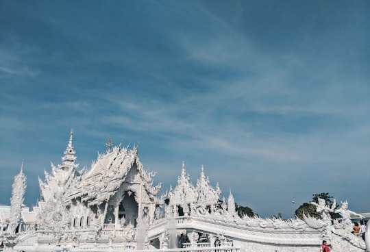 white concrete building under blue sky during daytime in The White Temple Thailand