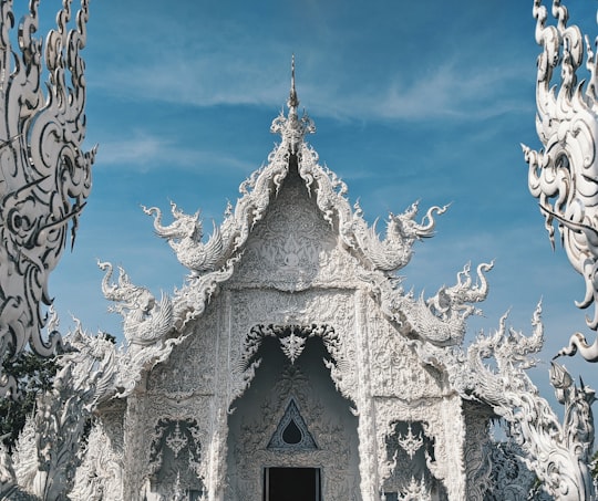 white concrete building under blue sky during daytime in The White Temple Thailand