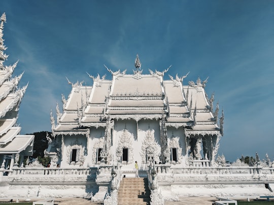 white concrete building under blue sky during daytime in The White Temple Thailand