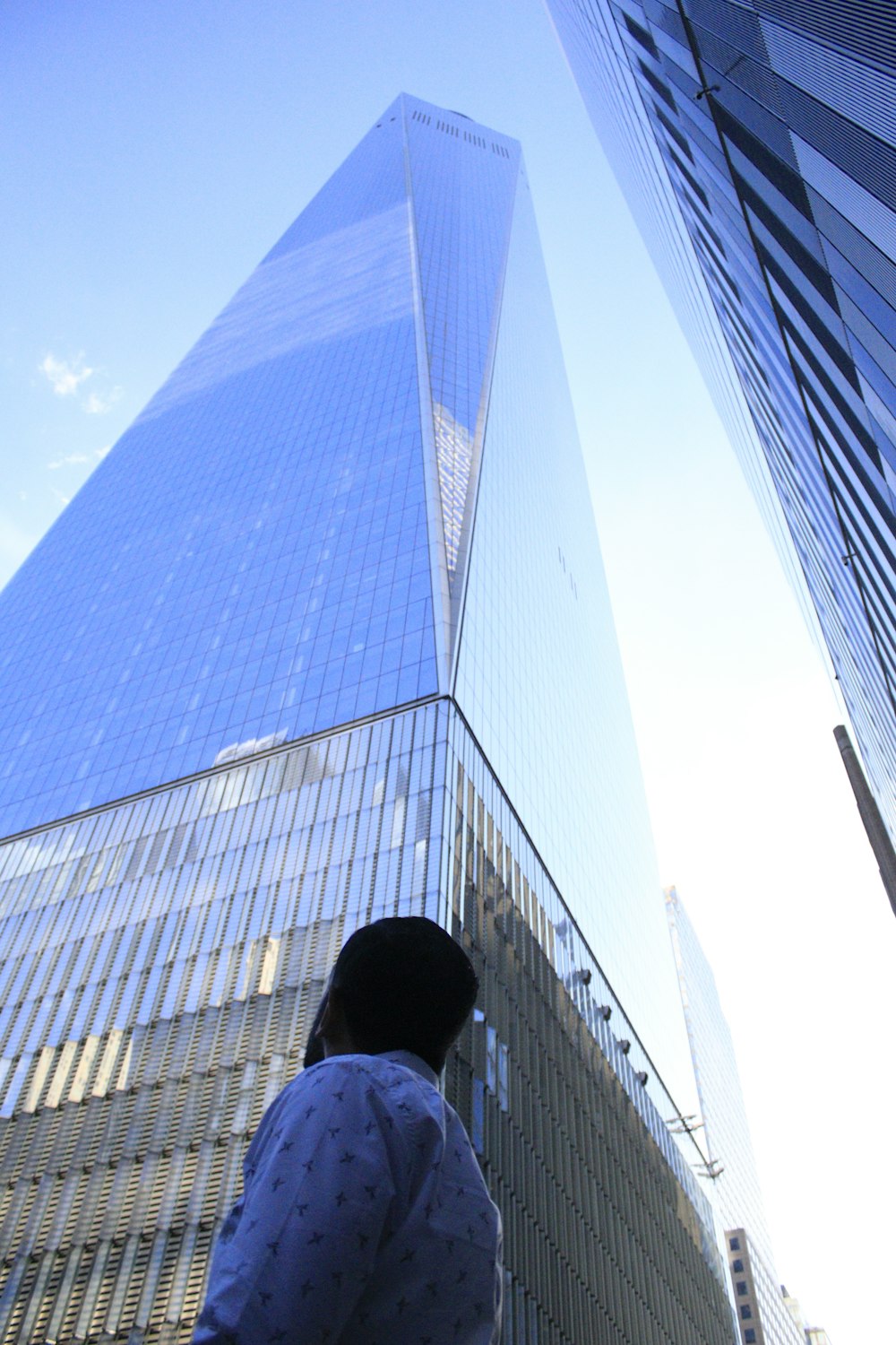 Mann in schwarzer Jacke steht tagsüber neben dem Gebäude