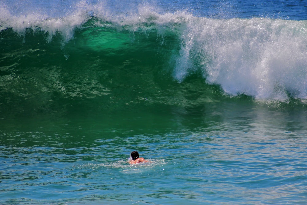 man surfing on sea waves during daytime