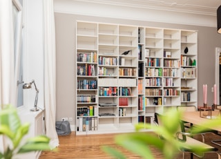 white wooden book shelves on brown wooden parquet floor