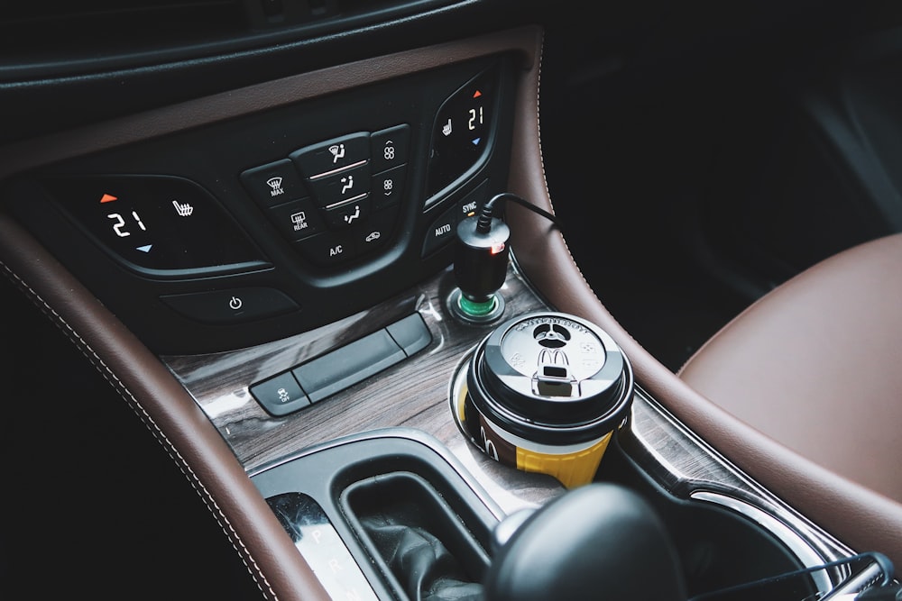 black and yellow disposable cup on car center console