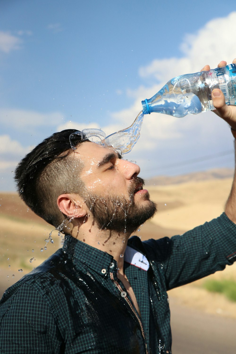 man in black shirt drinking water