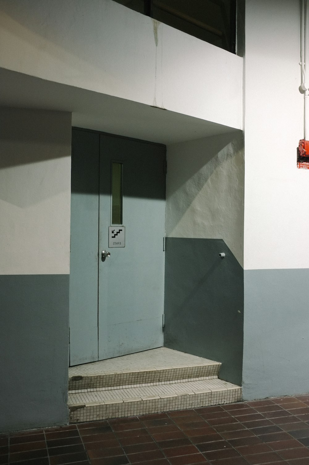 blue wooden door beside white wall