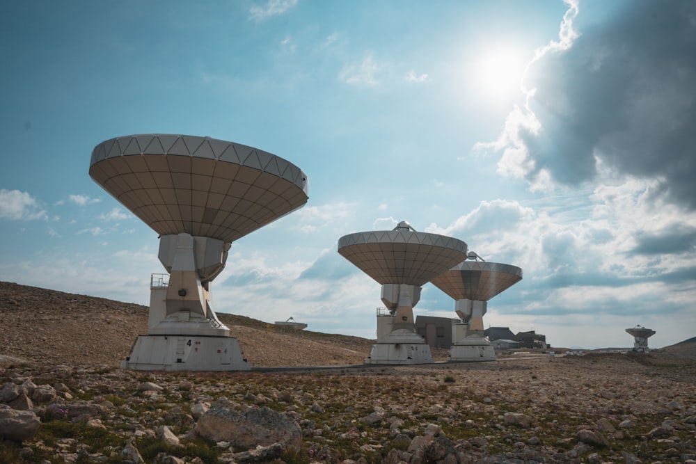 white satellite dish on brown field under white clouds and blue sky during daytime