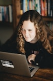 woman in black long sleeve shirt using gray laptop computer
