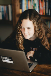 Close-up of a student engaging with a video library on a laptop with a lavender-themed interface.