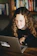 A focused young woman watching an educational criminology video on her laptop.