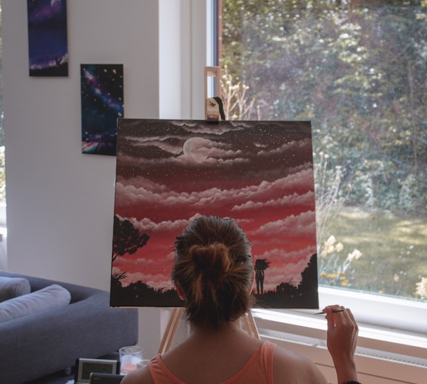 woman in pink tank top standing near window