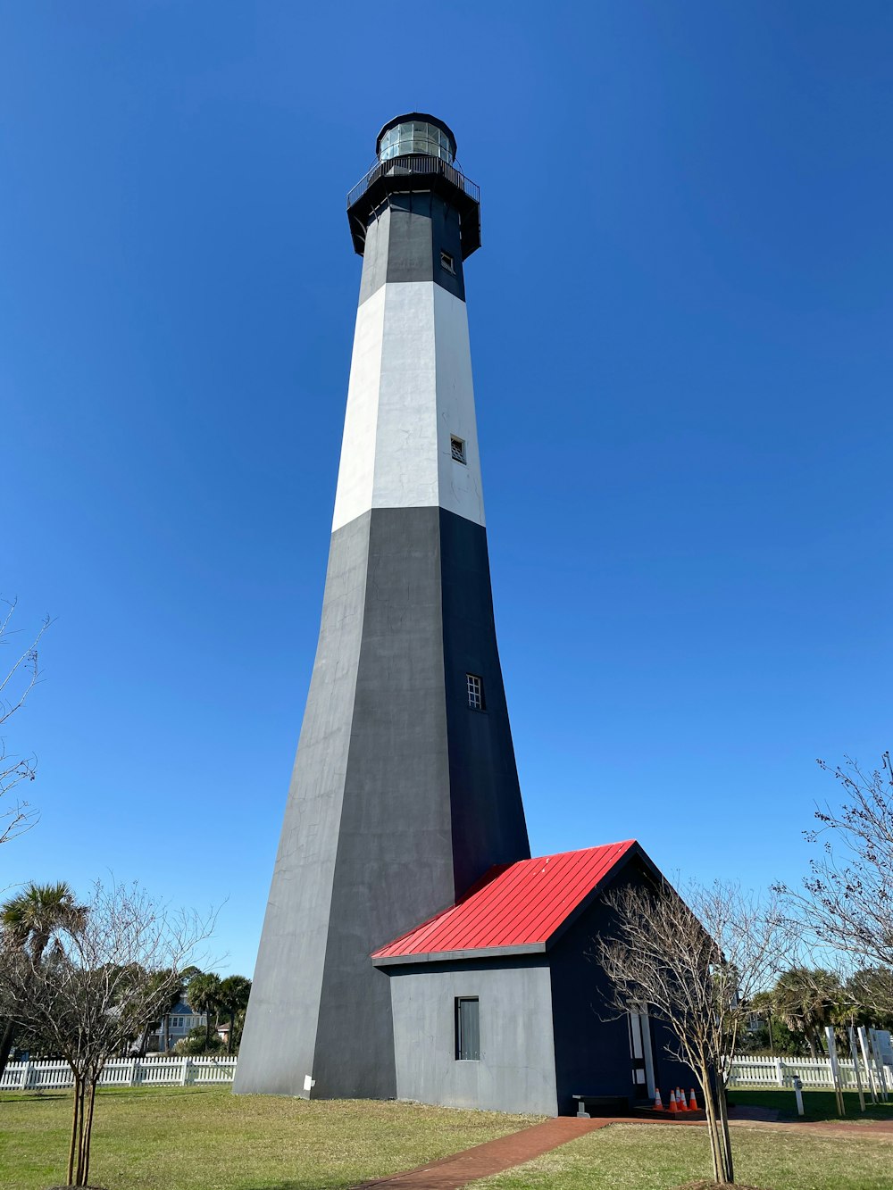 white and black concrete lighthouse under blue sky during daytime