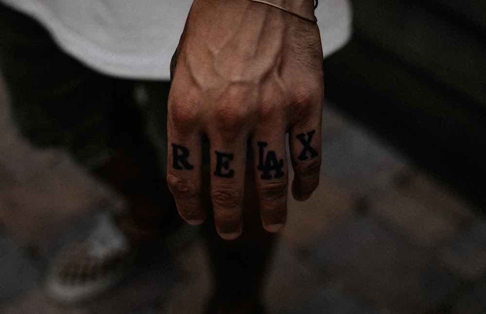persons hand with black tattoo
