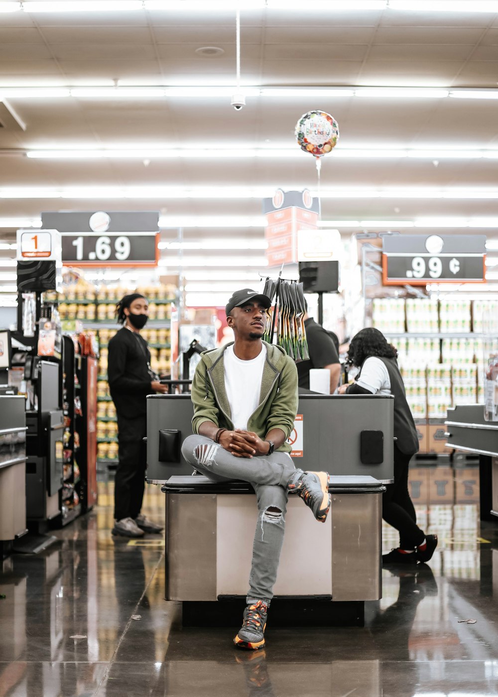 man in green hoodie sitting on counter