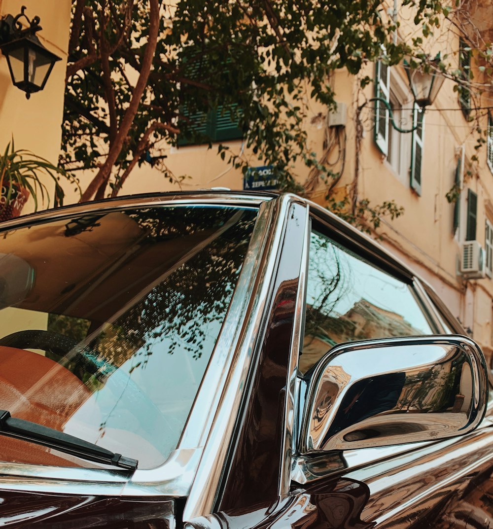 silver car parked beside brown building during daytime