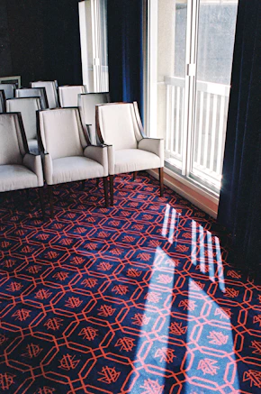 white leather sofa chair on red and blue area rug