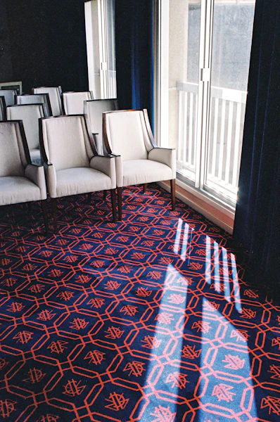 white leather sofa chair on red and blue area rug