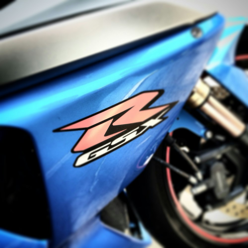 a close up of a blue motorcycle parked in a garage