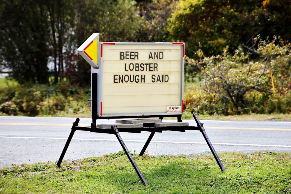 brown and white wooden signage on green grass field during daytime