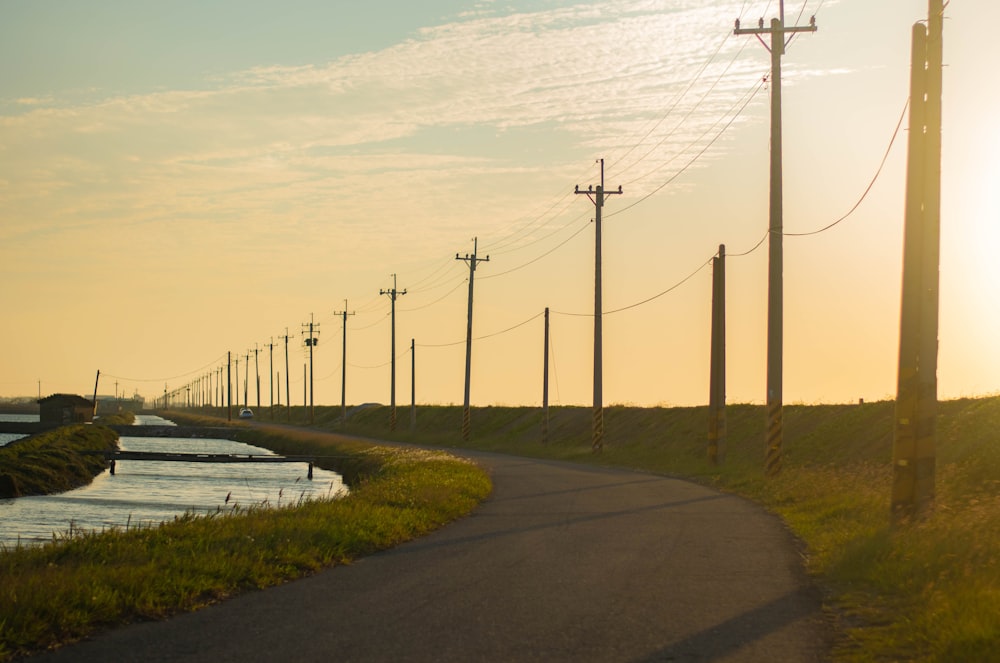 gray concrete road near body of water during daytime