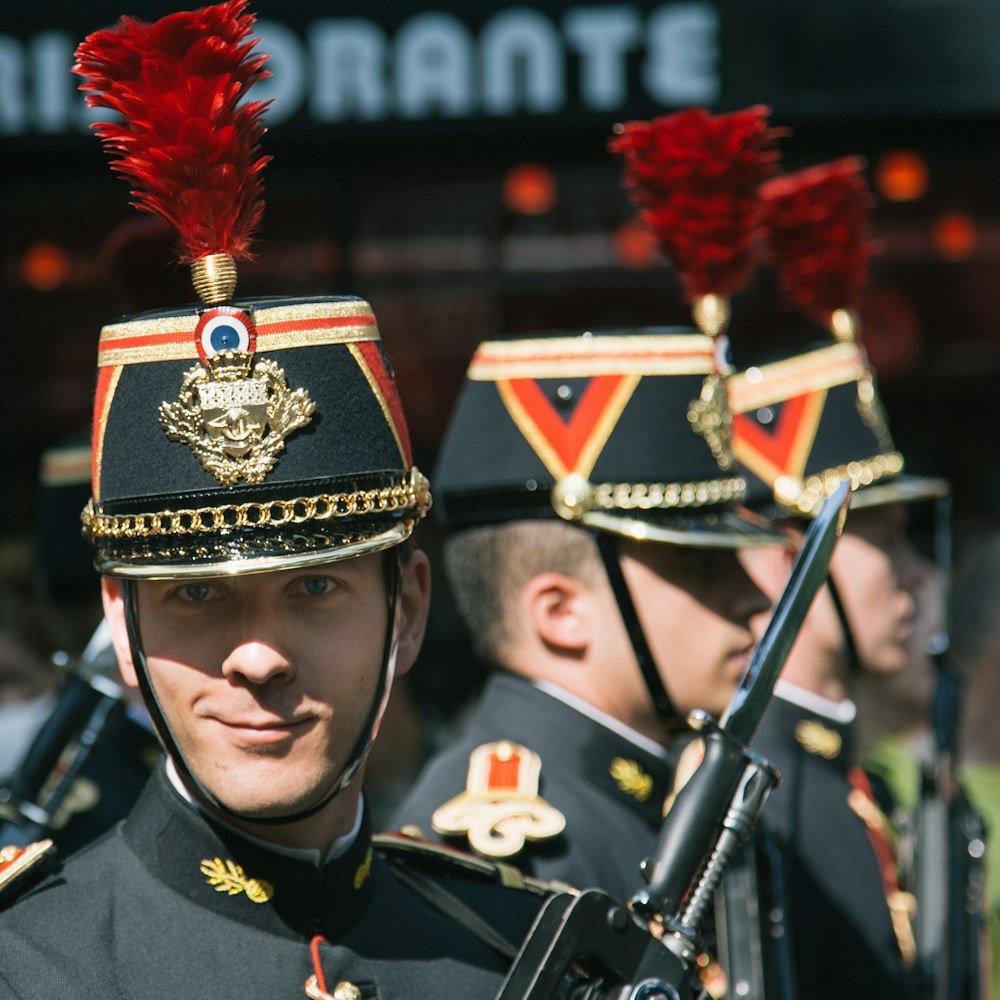 man in black and gold uniform holding black and red rifle